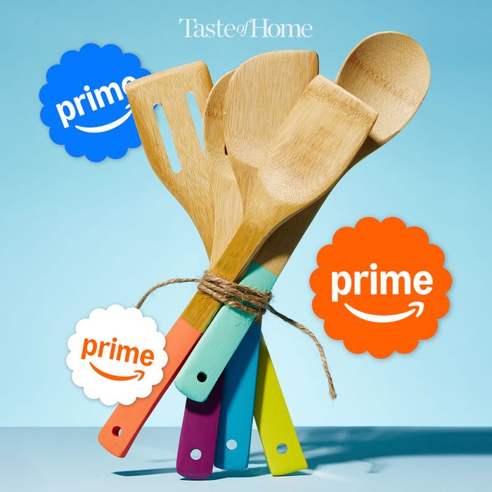 colorful wooden kitchen utensils tied together and standing up against blue background with Prime stickers around