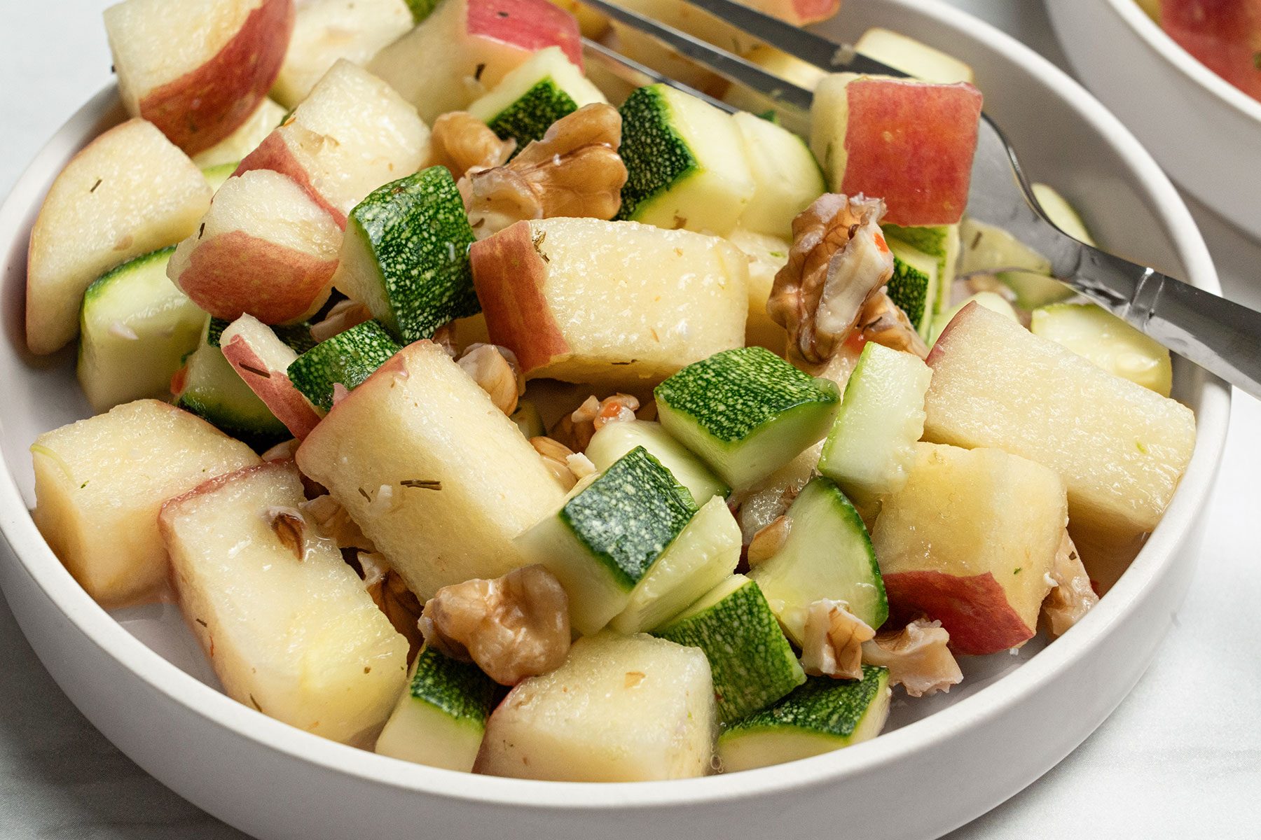 Apple Zucchini Salad in a white bowl.