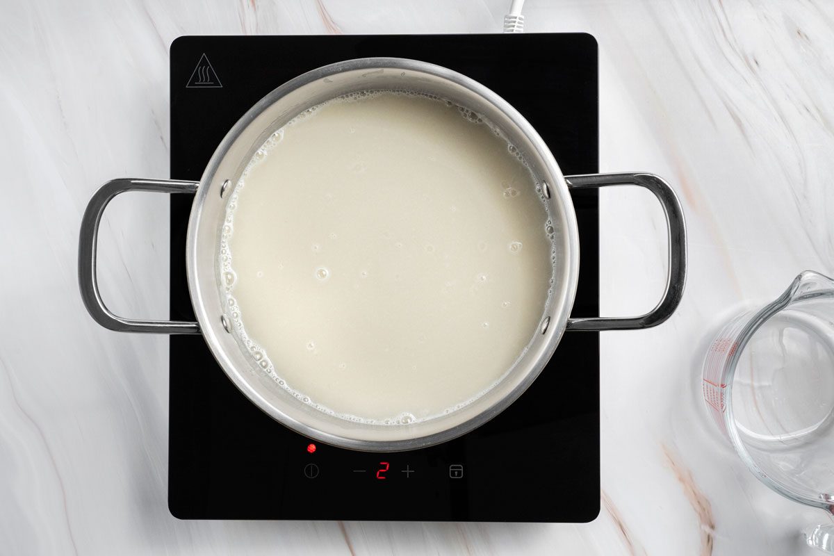 Overhead shot of stir in water until smooth; bring to a boil; cook and stir for 2 minutes or until thickened and bubbly; all set on a marble surface;