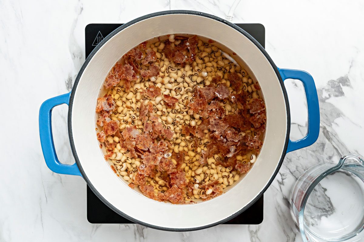 Place peas and bacon in a Dutch oven;