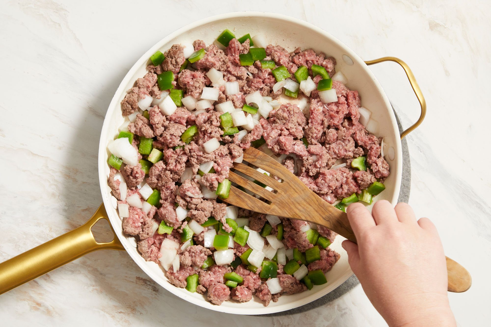Cooking beef, green pepper and onion in a large skillet