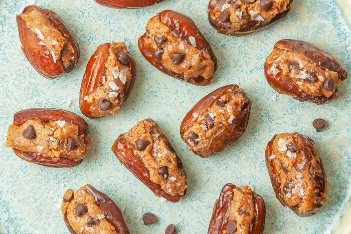 Closeup shot of Cookie Dough-Stuffed Dates; served ona ceramic plate; garnish with flaky sea salt just before serving;