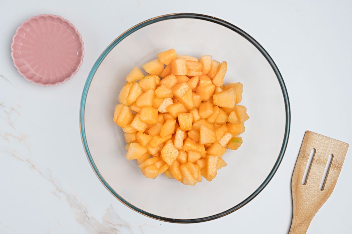 Overhead shot of fresh melon cubes in a large bowl