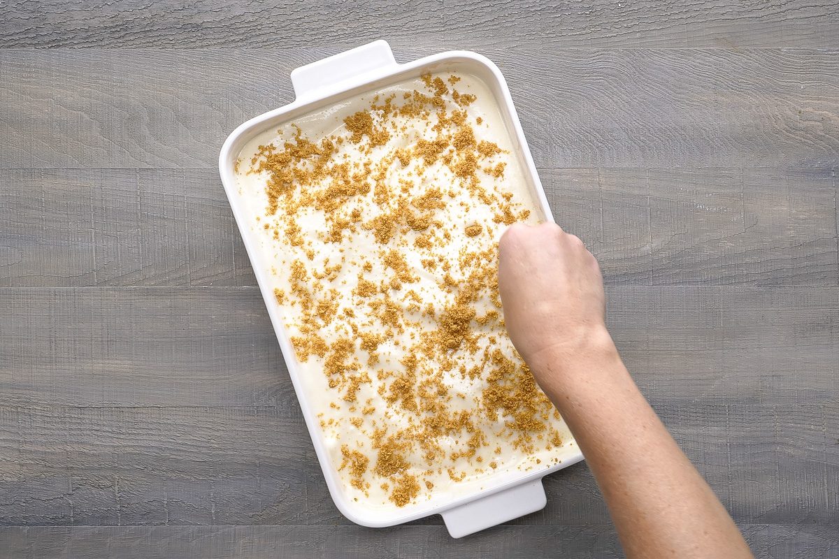 crumbs being sprinkled over baked cooled crust