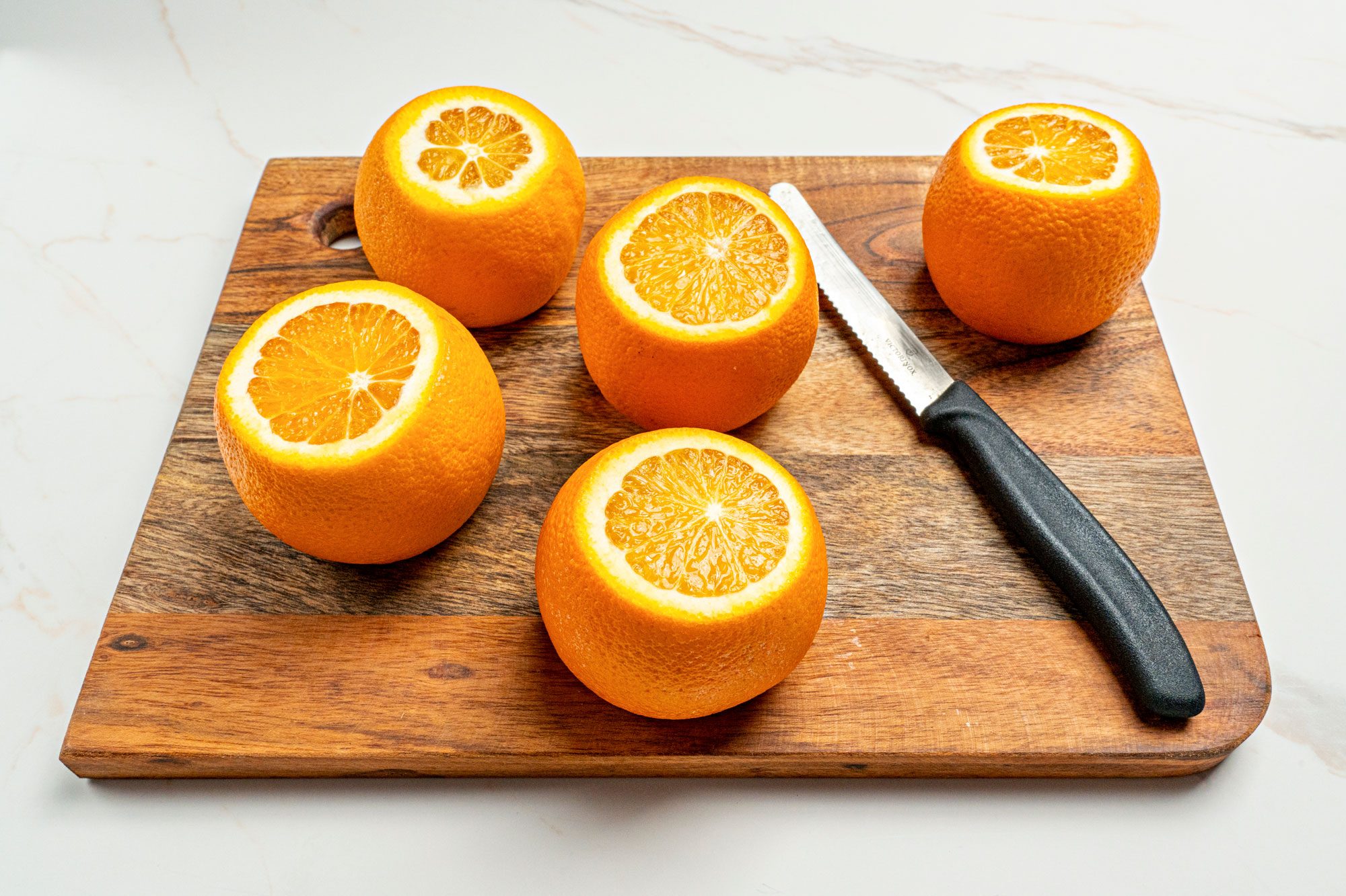 Cut a thin slice from the top and bottom of each orange