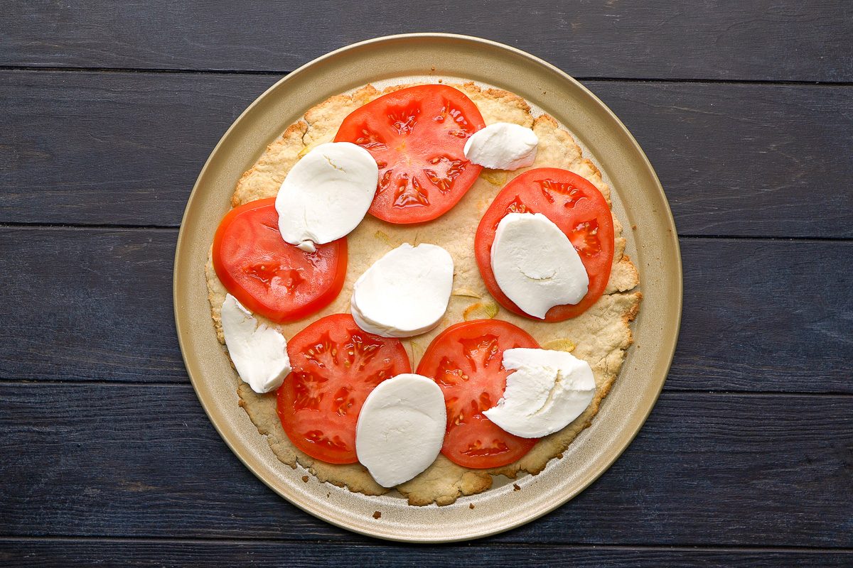 thinly sliced tomato and sliced fresh mozzarella added to dough