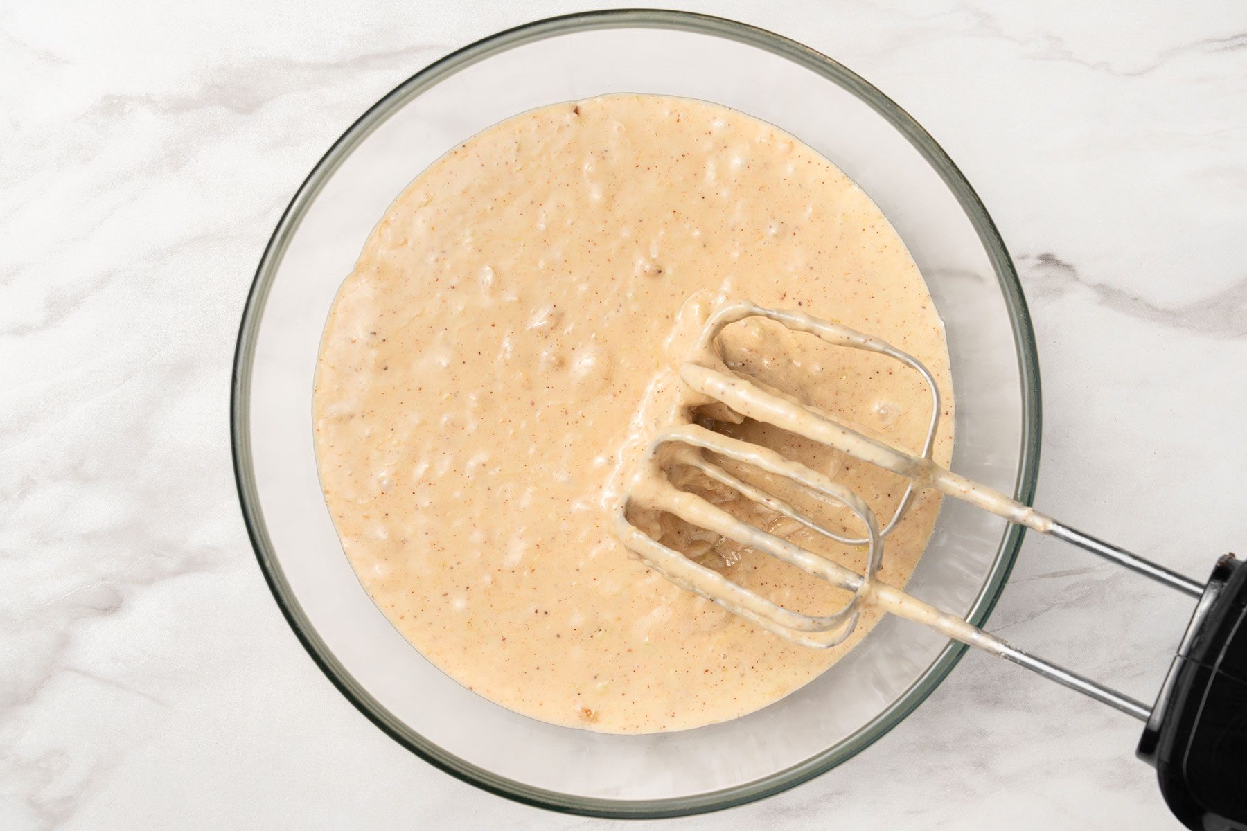 Flour and spice mixture beaten with egg mixture in a bowl.