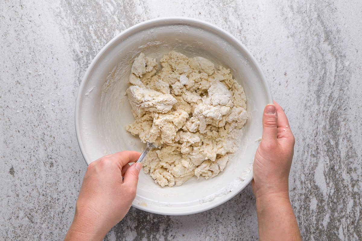 combining wet and dry mixtures in a bowl with a fork
