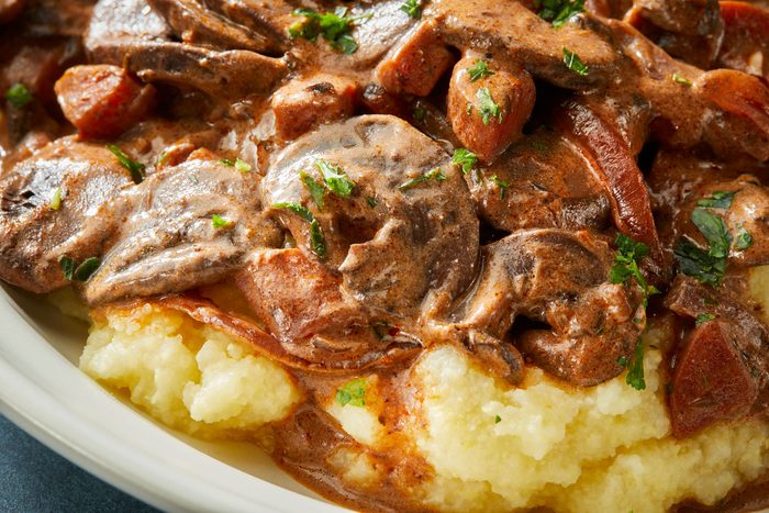 Close-up shot of Mushroom Bourguignon; served in a bowl; dark blue surface;