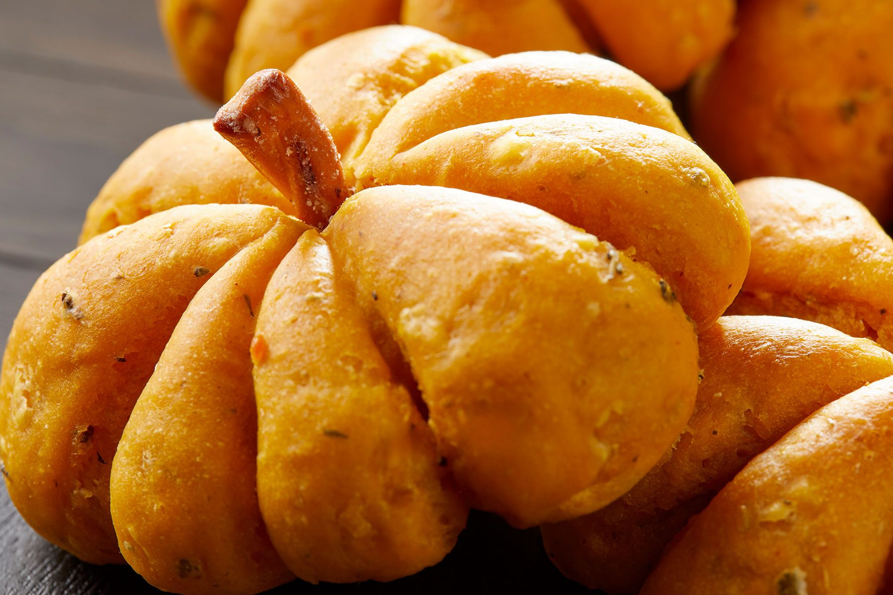 Close up shot of Pumpkin Shaped Rolls on top of each other.