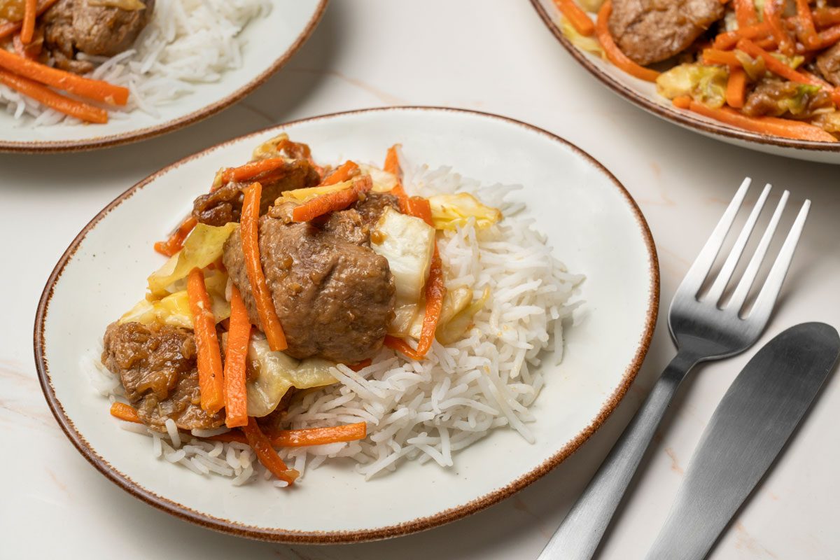 3/4 shot of Asian Pork Cabbage Stir-Fry served with hot cooked rice