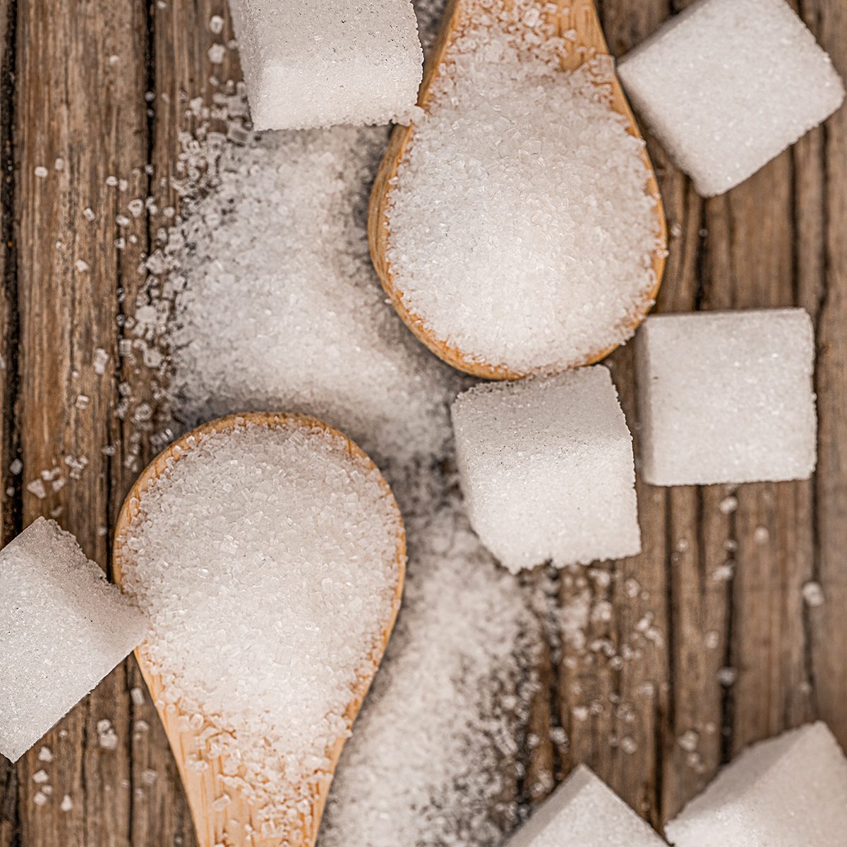 Sugar and Wooden Spoons on Wood Table