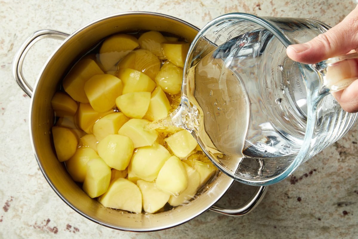 water being added to potato pieces in a six-quart stockpot