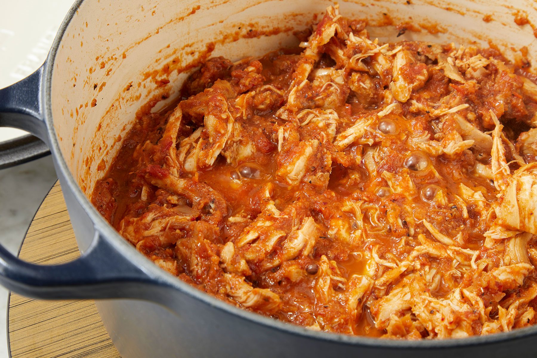 Mix shredded chicken in the puree mixture in a pan.