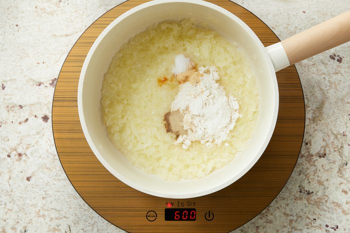 flour, salt, garlic powder and pepper added to onions being cooked in a pot