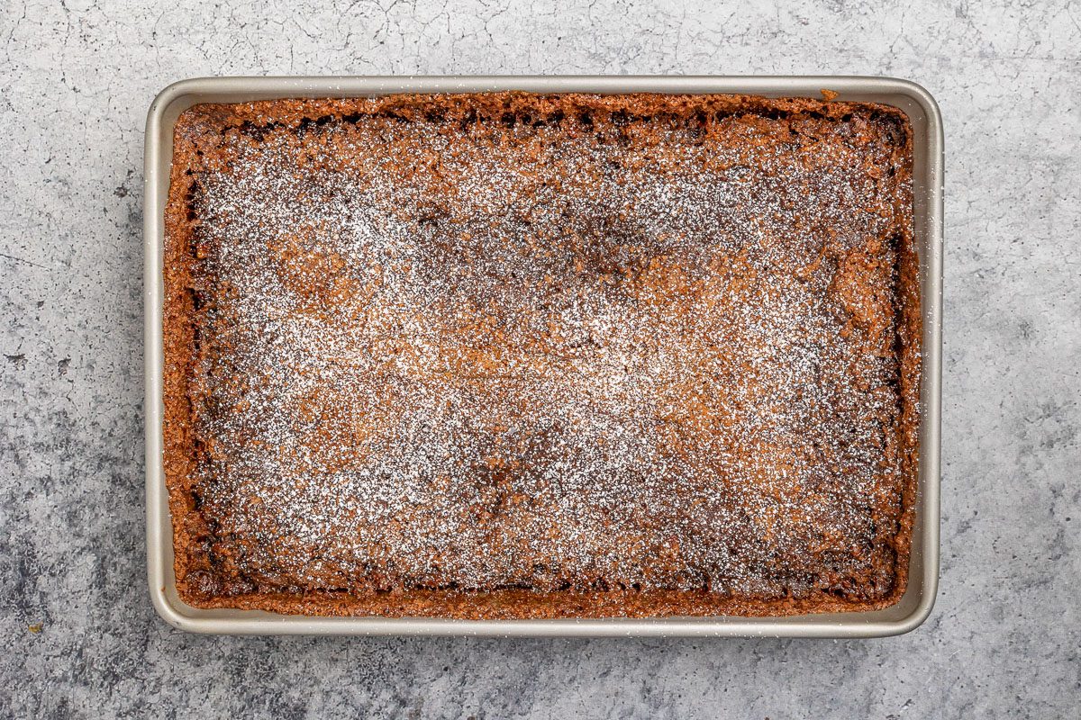 baked batter in a pan dusted with confectioners' sugar