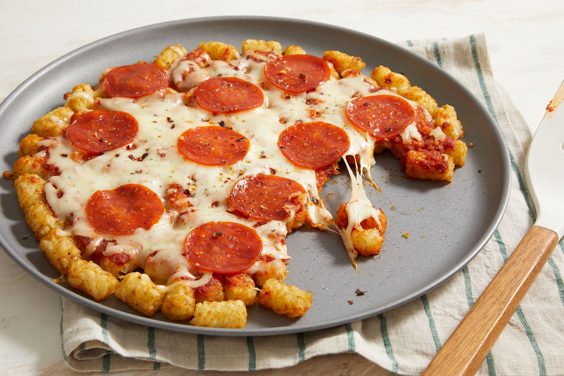 Baked pizza tater tots with melted cheese.