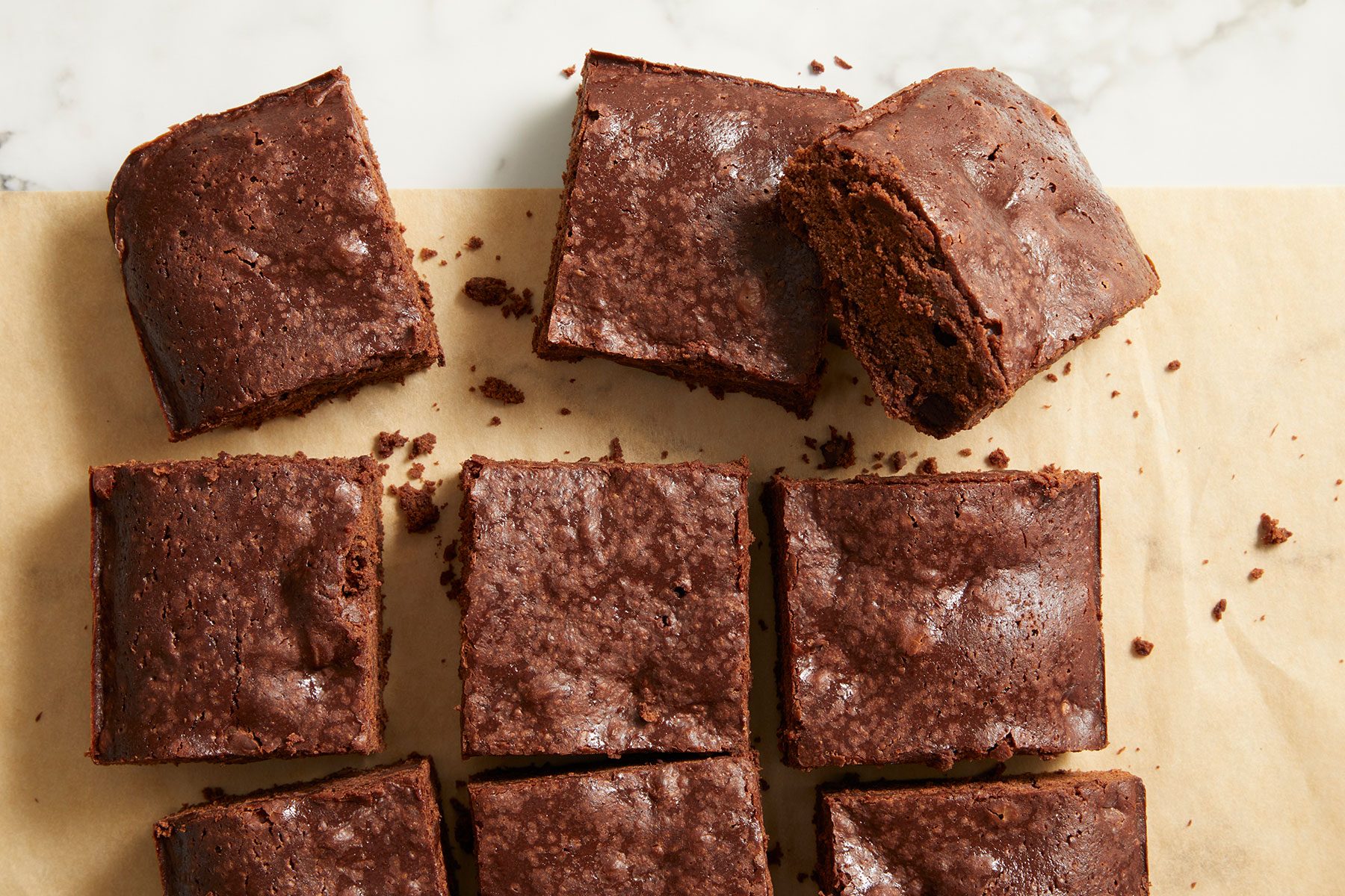Sourdough Brownies cut into small pieces on parchment paper.