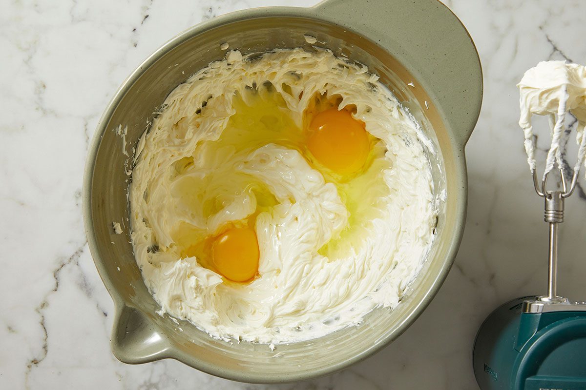 beat cream cheese and eggs in a bowl