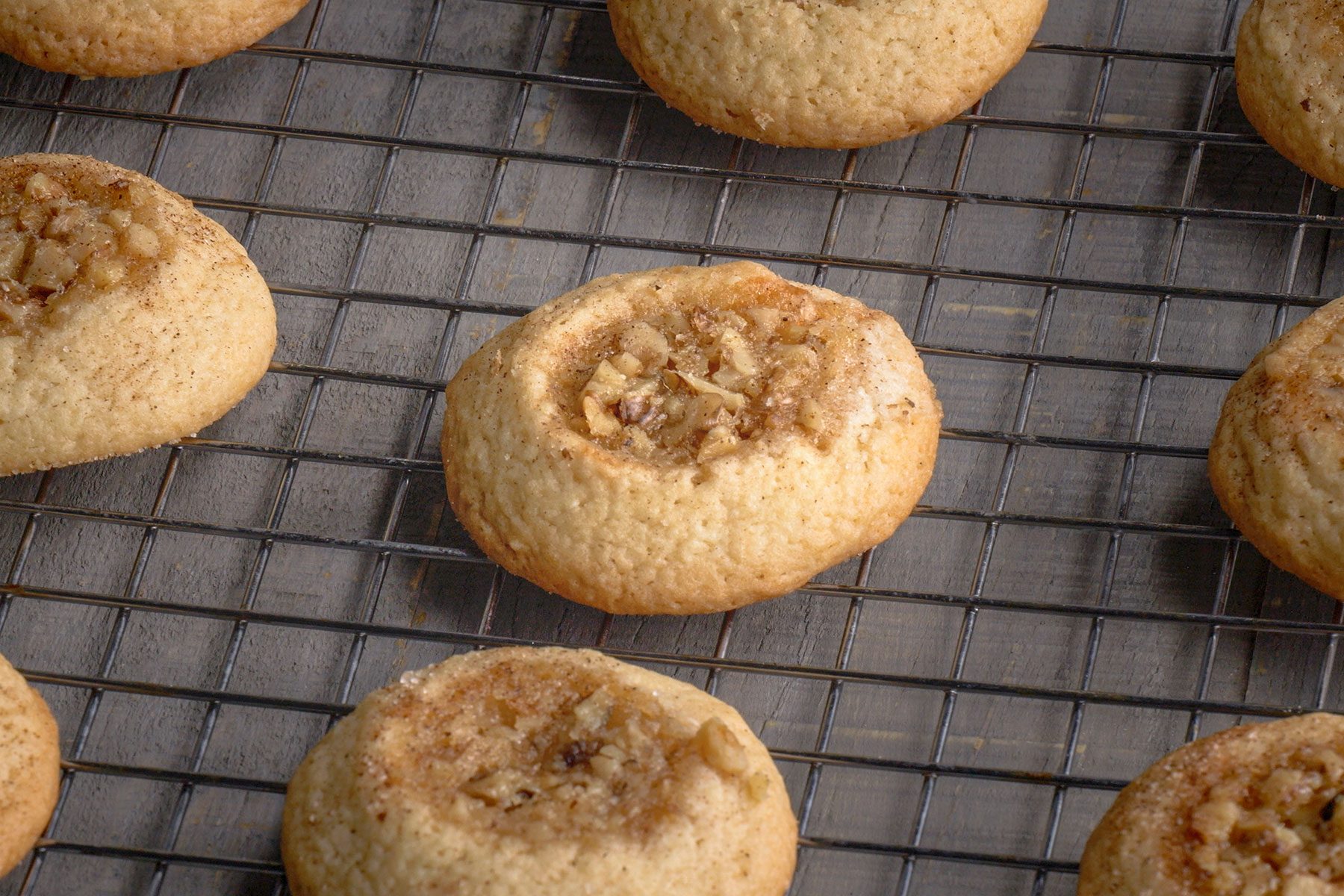 Browned Baklava Thumbprint Cookies on a wire rack.
