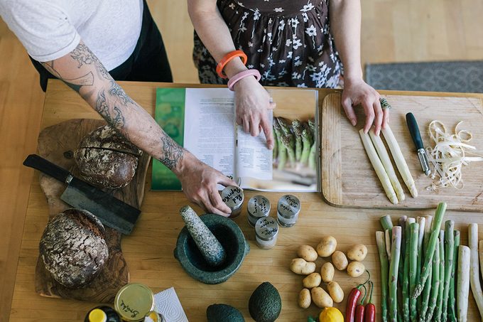 Overhead view of couple reading a cooking recipe.