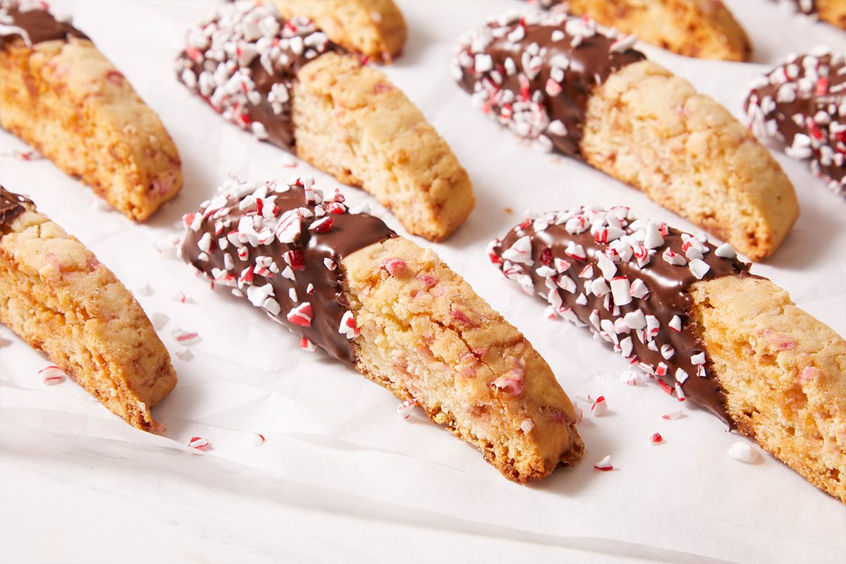 Close-up shot of Peppermint Biscotti halves dipped in dark chocolate and sprinkled with peppermint pieces.