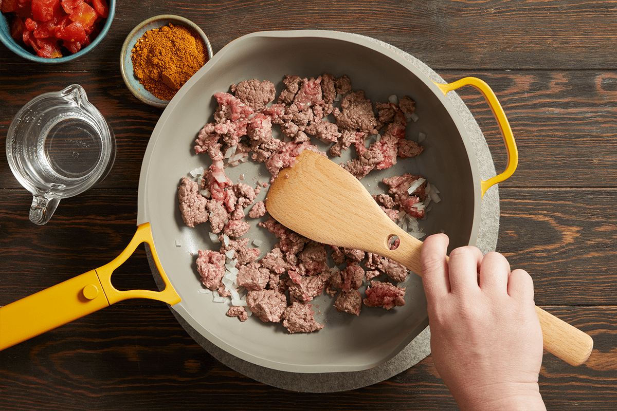 Cooking beef and onion in a skillet