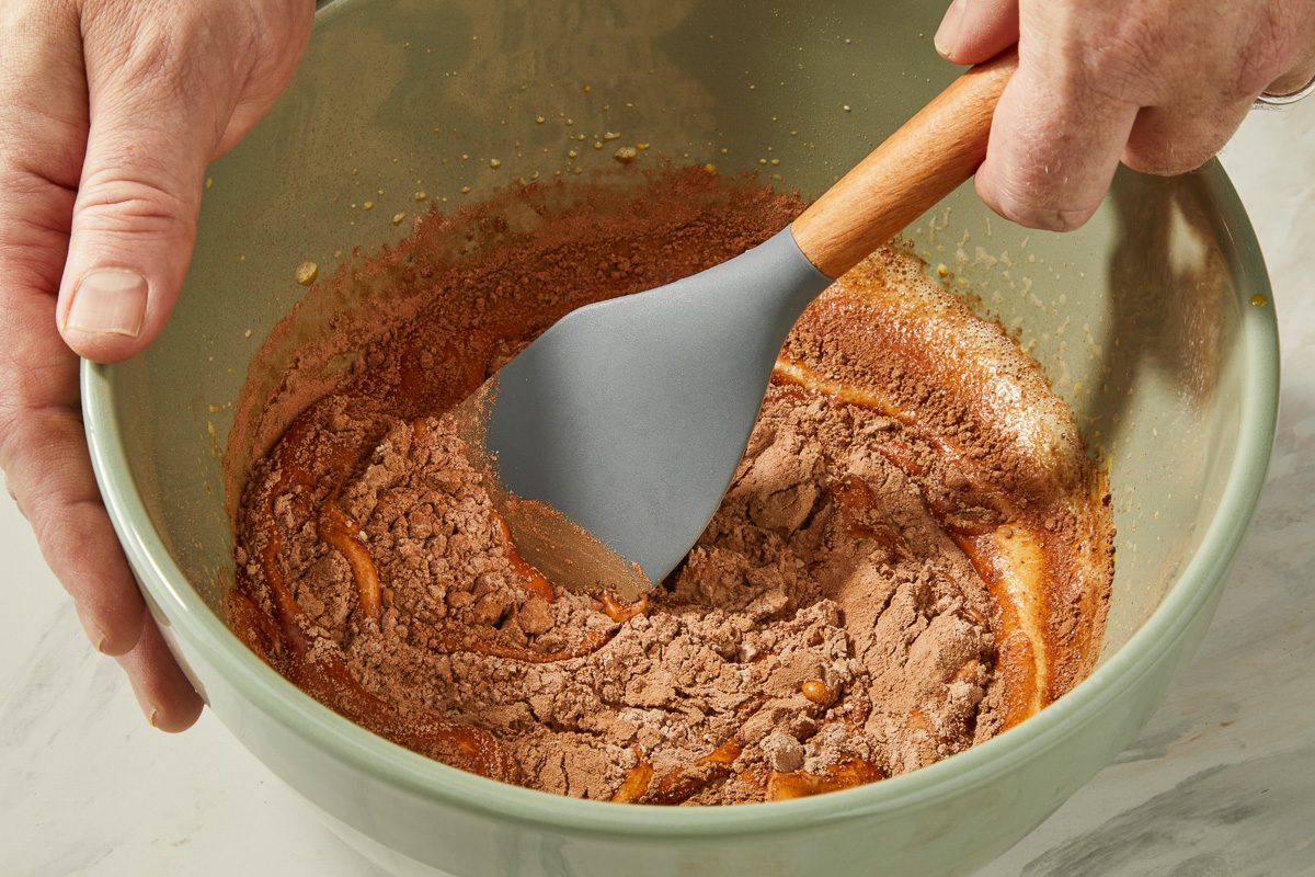 folding in flour mixture with egg yolk and vanilla mixture